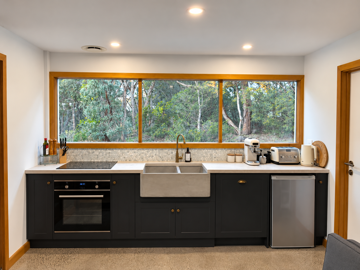 The upstairs kitchen with a wide window looking out to trees